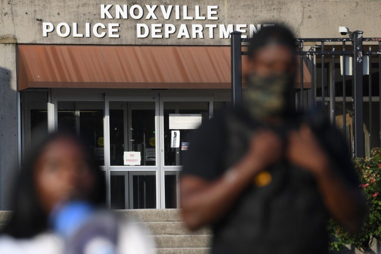 A Black police officer outside the Knoxville Police Department as a demonstrator speaks.