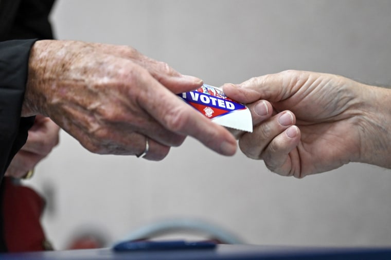 A voter receives an "I Voted" sticker after casting their ballot on the first day of in-person early voting on Oct. 2, 2022, in Las Vegas.