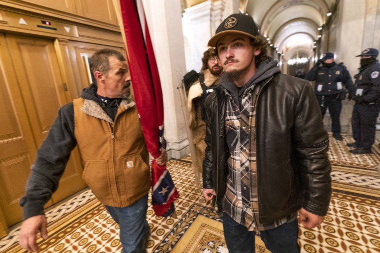 Kevin Seefried, left, walks along a hallway after a confrontation with Capitol Police officers outside the Senate Chamber inside the Capitol, on Jan. 6, 2021 in Washington. A federal judge on Wednesday, June 15, 2022, convicted Kevin Seefried and his adult son Hunter Seefried of charges that they stormed the U.S. Capitol together to obstruct Congress from certifying President Joe Biden’s 2020 electoral victory. (AP Photo/Manuel Balce Ceneta, File)