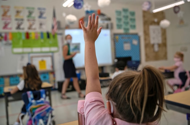 A student raises her hand during her first day of kindergarten on Sept. 9, 2020 in Stamford, Conn.