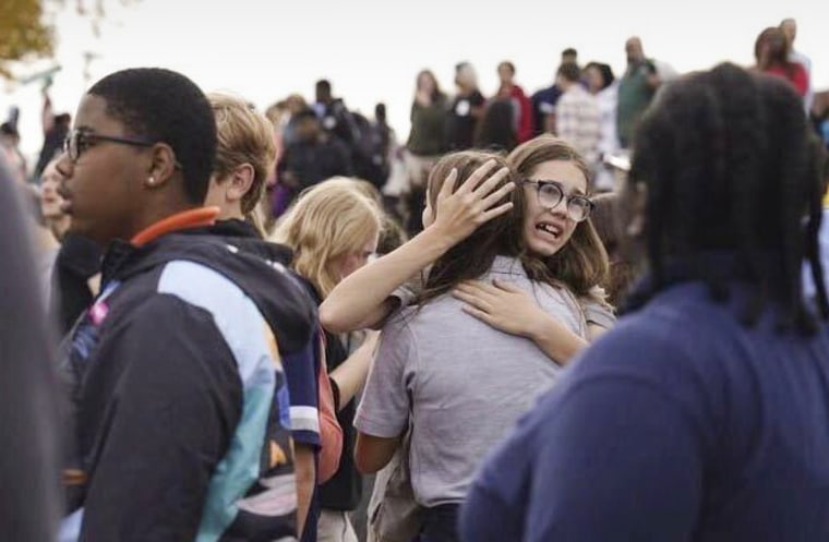 People gather outside after a shooting at Central Visual and Performing Arts high school in St. Louis, on Monday, Oct. 24, 2022. 