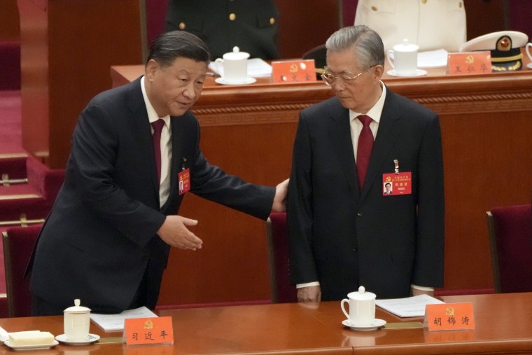 Chinese President Xi Jinping helps former Chinese President Hu Jintao to his seat at the opening ceremony of the 20th National Congress of China's ruling Communist Party held at the Great Hall of the People in Beijing, China