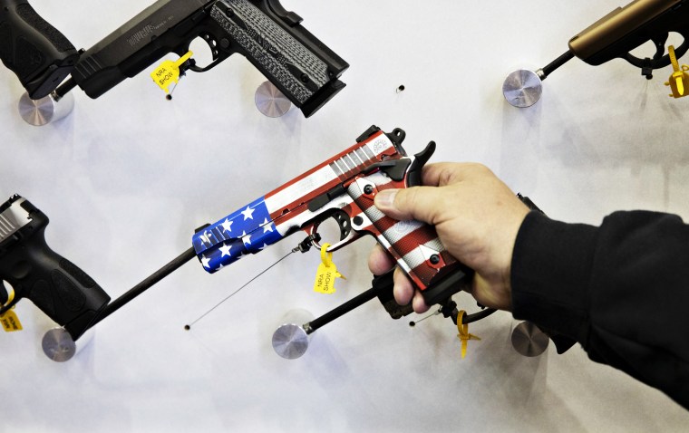 An attendee holds an American flag themed pistol during the NRA's annual meeting of members in Indianapolis on April 27, 2019.