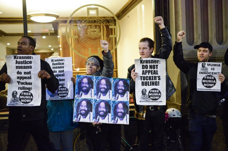 image: Fists are raised as activists rally outside the District Attorneys Office on December 12, 2018 to call on DA Larry Krasner to not appeal a recent decision of PA Supreme Court Justice Tucker in Philadelphia.