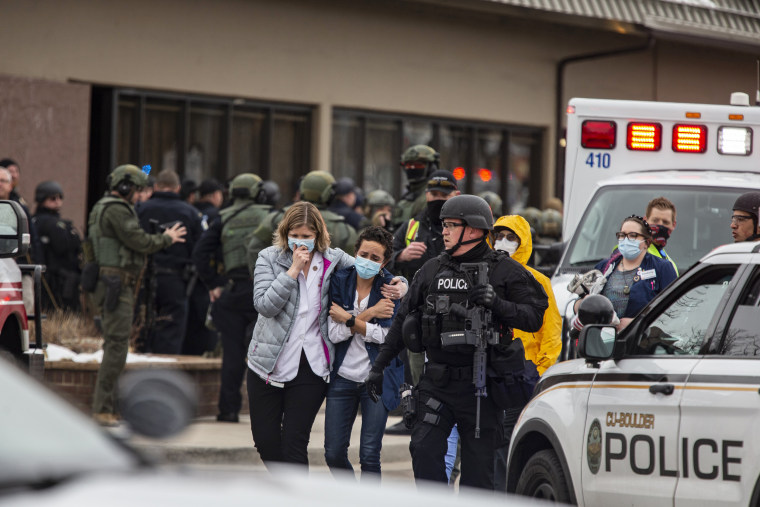 Healthcare workers walk out of a King Sooper's Grocery store after a gunman opened fire on March 22, 2021 in Boulder, Colo.