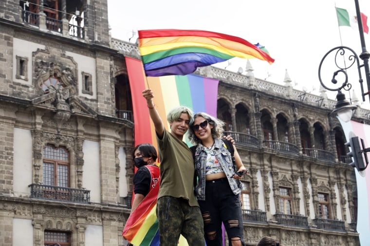 People wave a pride flag during a LGBTQ+ pride march