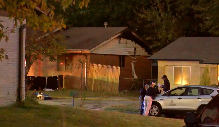 Medical examiners at the scene of a house fire in Broken Arrow, Okla. on Thursday.