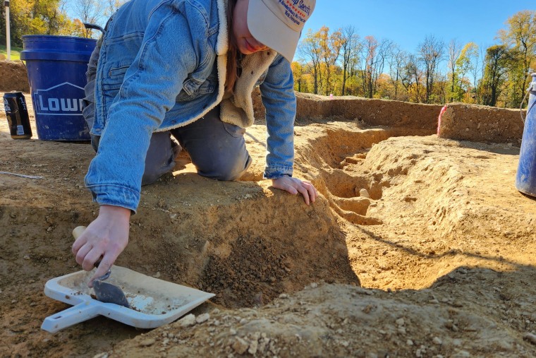 Jane C. Skinner excavates post holes at the bottom of the stockade trench, on Oct. 27, 2022, in York, Penn.