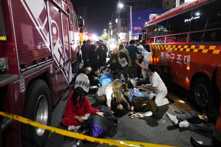 Injured people are helped at the scene of a crushing accident in Seoul on Oct. 30, 2022.