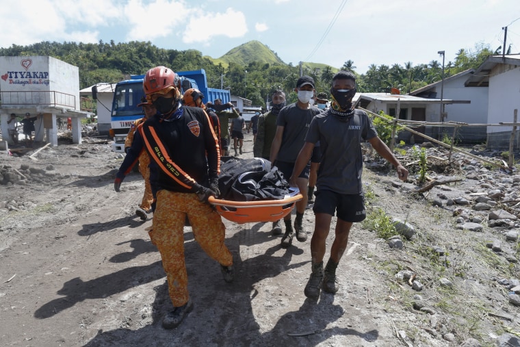 Rescuers carry a body on Sunday in Datu Odin Sinsuat, a town in the southern Philippines.