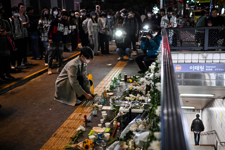 A man pours a glass of an alcoholic beverage, in tribute to those who were killed in a Halloween stampede late on Saturday in Seoul's Itaewon district, on Oct. 30, 2022.