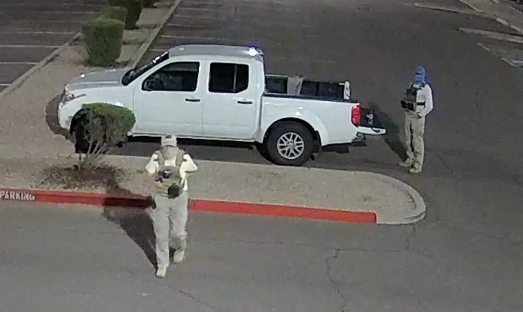 Armed individuals dressed in tactical gear at the site of a ballot drop box in Mesa, Ariz., on Oct. 21, 2022.