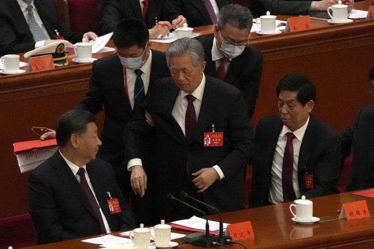 El expresidente chino, Hu Jintao, en el centro, escoltado por dos hombres durante la ceremonia de clausura del 20º Congreso Nacional del gobernante Partido Comunista de China en el Gran Salón del Pueblo en Pekín, el sábado 22 de octubre de 2022.