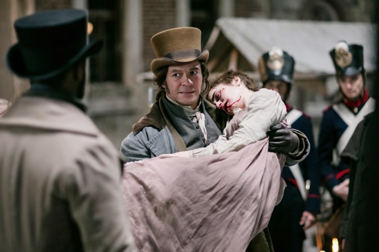 David Oyelowo (back to camera), Dominic West and Lily Collins in Les Miserables.