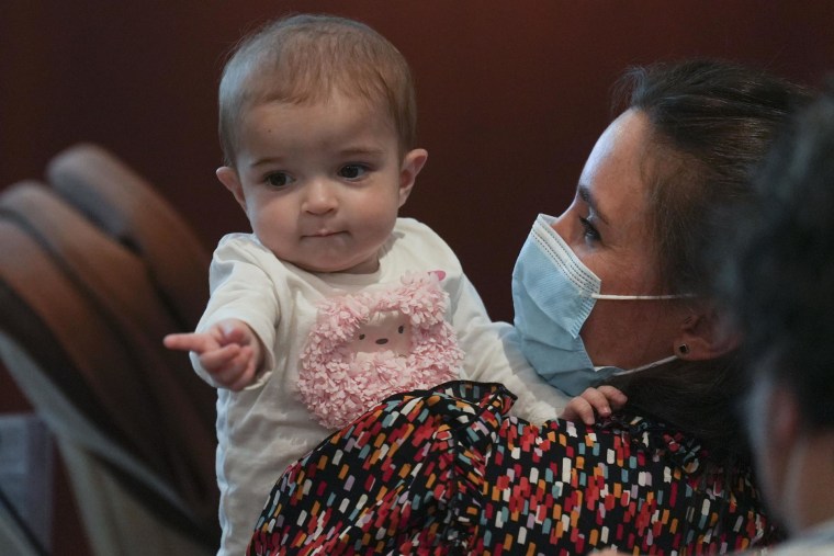 La pequeña Emma, de 13 meses, en brazos de su madre, Ana. El hospital público madrileño de La Paz ha realizado con éxito por primera vez en el mundo un trasplante multivisceral de intestino procedente de una donación.