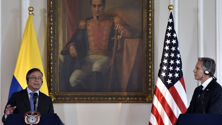 El presidente colombiano Gustavo Petro habla con micrófono en el Palacio de Nariño frente a una bandera de su país y un retrato de Simón Bolívar, en una conferencia de prensa conjunta con Antony Blinken, el secretario de Estado de EE.UU.