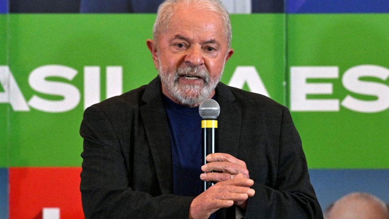 El brasileño Luiz Inácio Lula da Silva, con un saco de traje negro y su típica barba corta canosa, sostiene un micrófono durante un evento