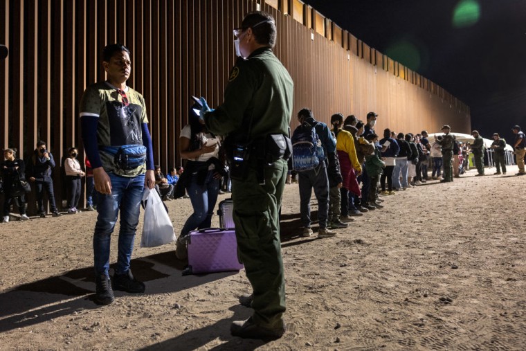 Un grupo de solicitantes de asilo espera órdenes de agentes fronterizos cerca de Yuma, Arizona, el 26 de septiembre de 2022.