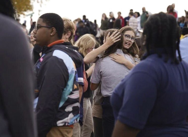 Unas personas se reúnen afuera de una escuela secundaria de San Luis, Missouri, luego de que se registró un tiroteo, el lunes 24 de octubre de 2022. 