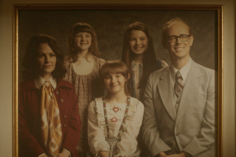 framed family photo of Anna Paquin as Mary Ann Broberg, Elle Lisic as Young Susan Broberg, Hendrix Yancey as Young Jan Broberg, Mila Harris as Young Karen Broberg, Colin Hanks as Bob Broberg