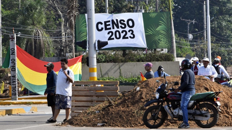 Manifestantes bloquean un camino en la ciudad boliviana de Santa Cruz con ayuda de sacos de tierra enfrente de un letrero que dice "Censo 2023"