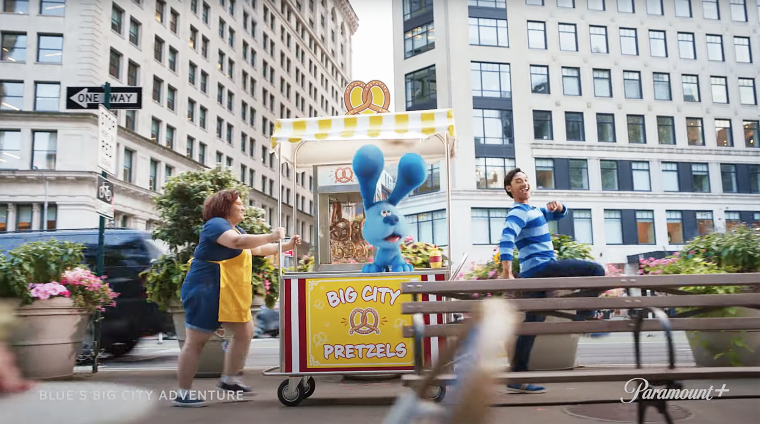 Blue is pushed in a pretzel stand with Jost leading the way through NYC