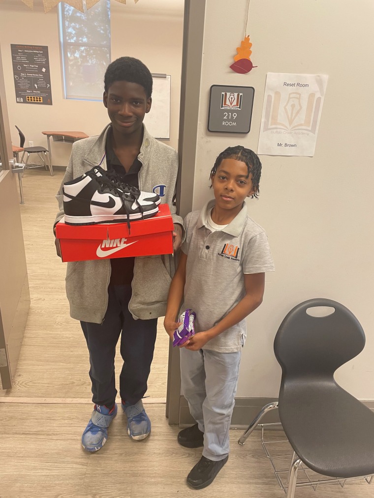 Melvin Anderson, 12, and Romello "Mello" Early showing Mr. Brown the new sneakers. 
