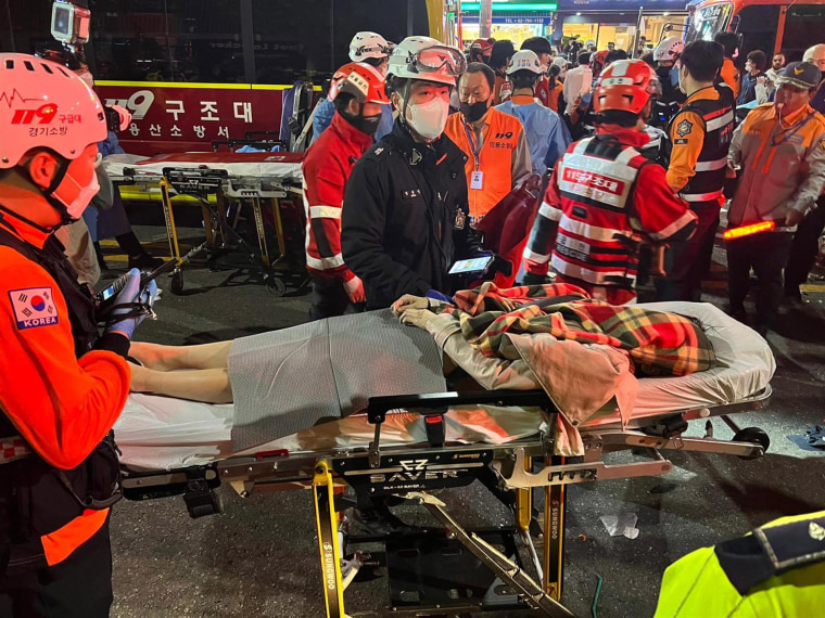 Rescatistas trasladan a una persona herida en una camilla en el distrito de Itaewon de Seúl.