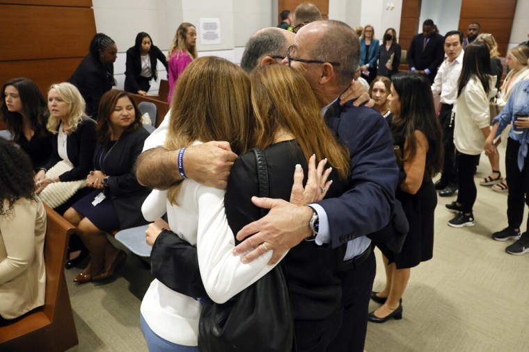 Linda Beigel Schulman, Michael Schulman, Patricia Padauy Oliver y Fred Guttenberg, familiares de las víctimas, se abrazan mientras esperan un veredicto, el jueves 13 de octubre de 2022.