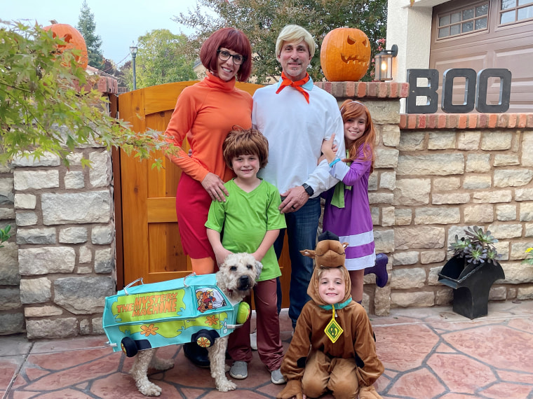 Family costumes with store baby and dog