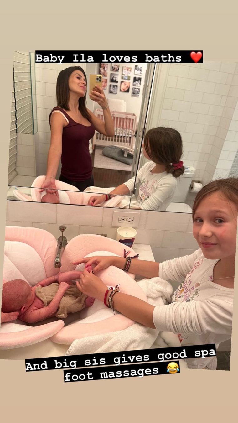 Ilaria gets some help at bath time from her mom and her big sister.