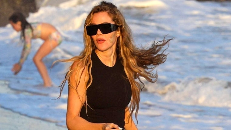 Khloé Kardashian en la playa mostrando su marca en el rostro.