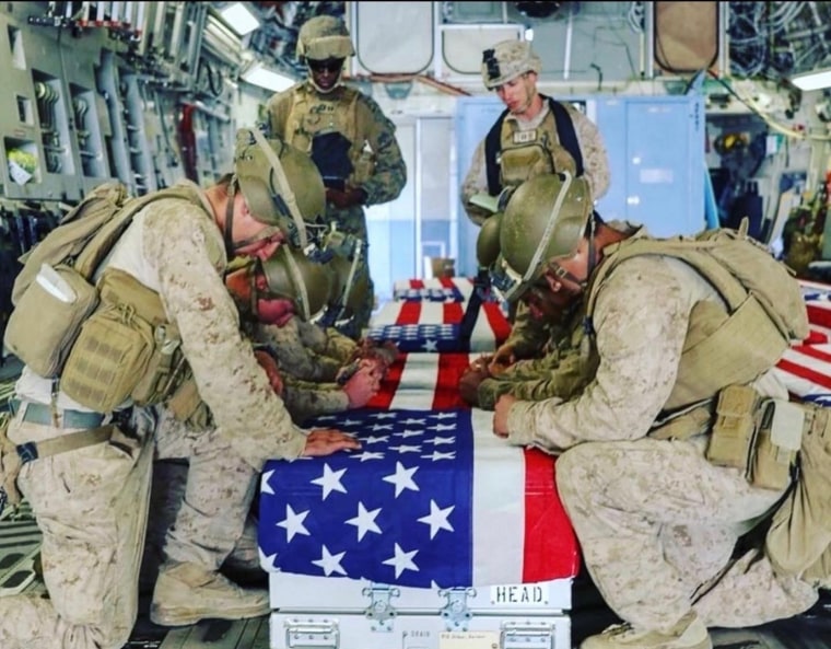 Fellow Marines kneel over the coffin of Kareem Nikoui en route to Dover Air Force Base.