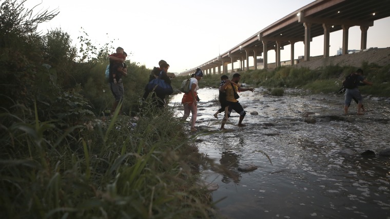 Migrantes venezolanos cruzan a pie el Río Grande en su camino hacia la frontera de Estados Unidos para entregarse a la patrulla fronteriza, desde Ciudad Juárez, México, el 13 de octubre de 2022.