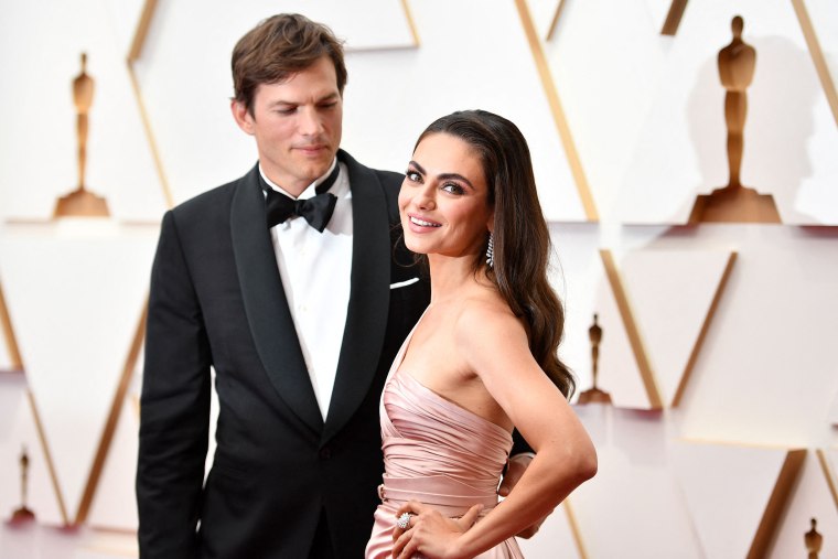 Ashton Kutcher (L) and wife US actress Mila Kunis attend the 94th Oscars