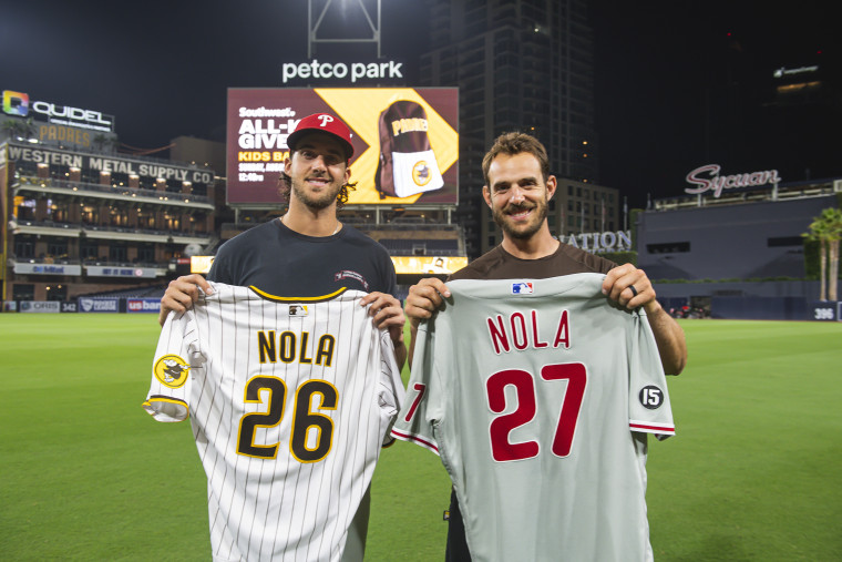 Austin Nola #26 of the San Diego Padres swaps jerseys with his brother Aaron Nola #27 of the Philadelphia Phillies on August 21, 2021 at Petco Park in San Diego, California.