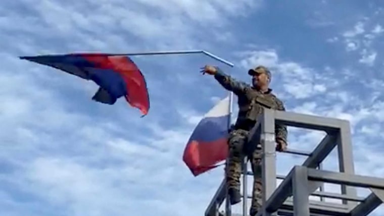 Un miembro de las tropas ucranianas derriba una bandera de la República de Donetsk, izada en un monumento en Lyman, Ucrania, en esta captura de pantalla obtenida de un vídeo de las redes sociales publicado el 1 de octubre de 2022.