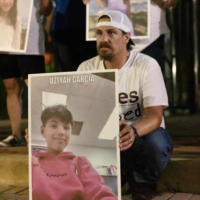 Brett Cross, holding a picture of his son, Uziyah "Uzi" Garcia. Uzi was killed alongside 18 of his classmates and two teachers inside Robb Elementary School.