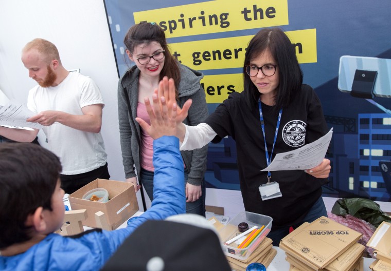 Jessica Wade high-fives an audience member at a presentation.