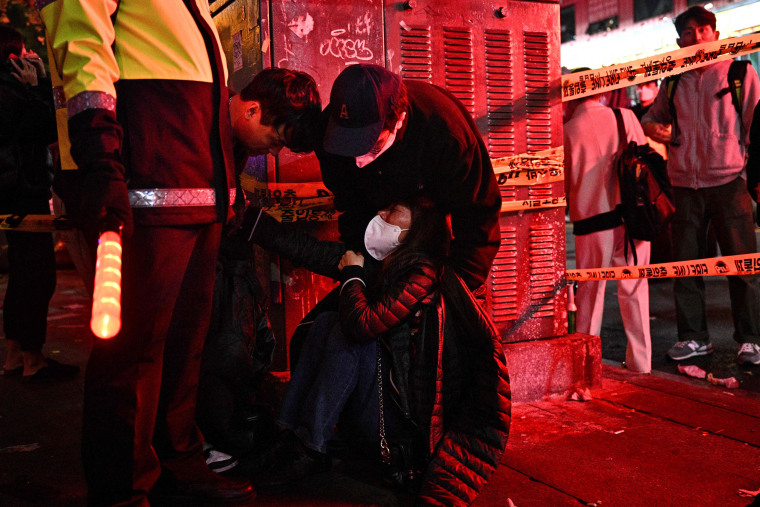 A woman is attended to as dozens of people suffered cardiac arrest in the popular nightlife district of Itaewon.