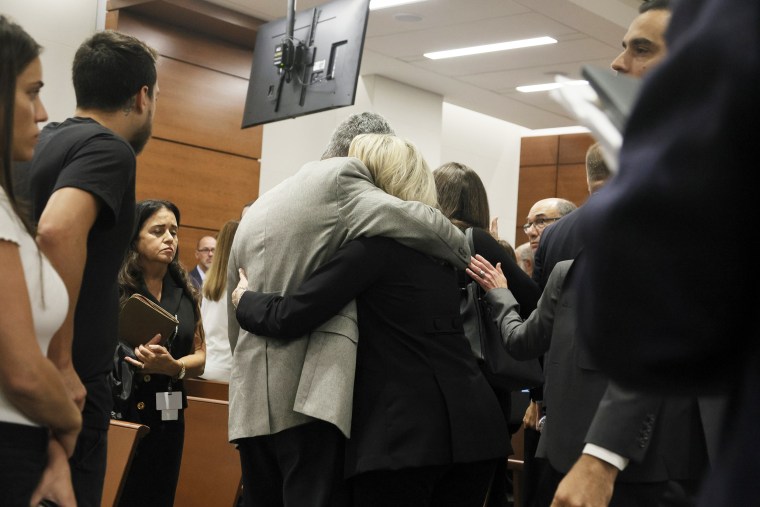 A family hugs during the trial of Marjory Stoneman Douglas High School shooter Nikolas Cruz