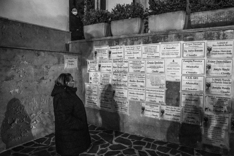 A person reads funeral posters for Claudio Mandia