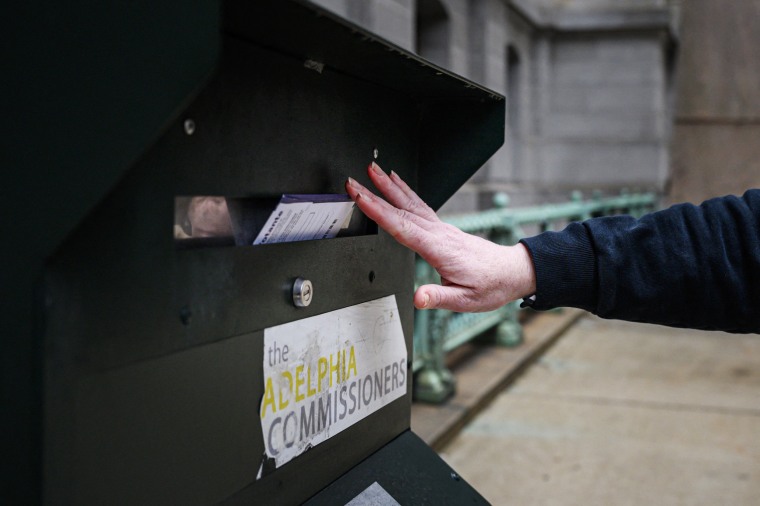 A voter casts their ballot at a drop box at Philadelphia city hall on Oct. 24, 2022. 