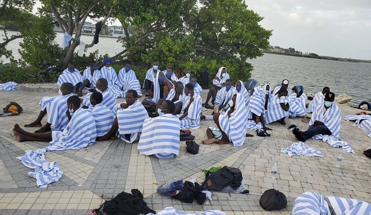 Haitian migrants on shore wrapped in towels after a boat ran aground in the Florida Keys off Key Largo on March 6, 2022. 