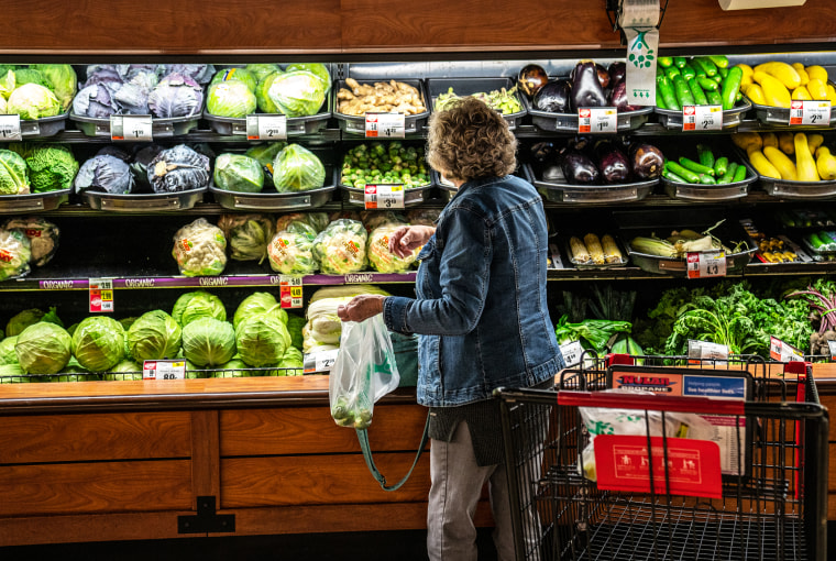 A woman selects fresh vegetables at a Tops Super Market on Oct. 27, 2022 in Greenville, N.Y.