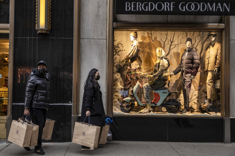 Shoppers walk past a Bergdorf Goodman store on Fifth Avenue in New York on Dec. 27, 2021.