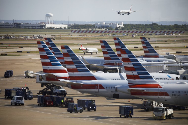Airplanes are parked at passenger gates at Dallas-Fort Worth International Airport 