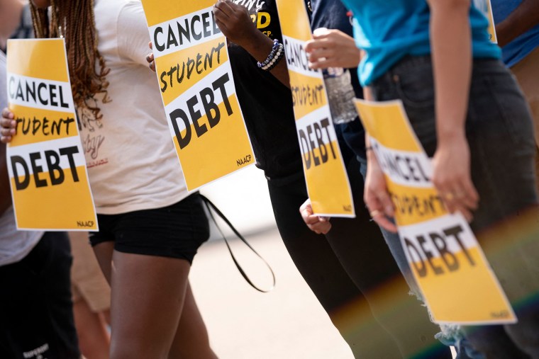 Activists hold "cancel student debt" signs during a rally in front of the White House