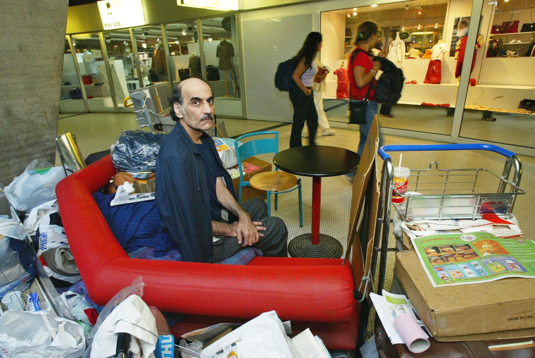 Mehran Karimi Nasseri sits among his belongings at Charles De Gaulle Airport