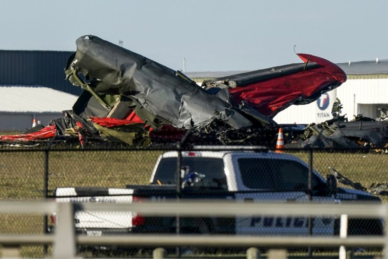 Debris from two planes that crashed during an airshow at Dallas Executive Airport lie on the ground on Nov. 12, 2022.